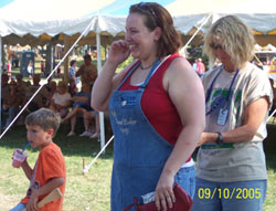 A contestant smiles and she waits for her apron to be tied. Click the photo to see a closer view.