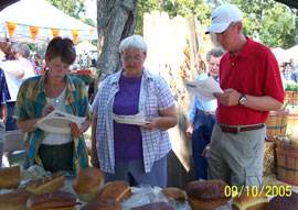 Our judges taste and view the loaves of bread for the contest. Click the photo to see a closer view.